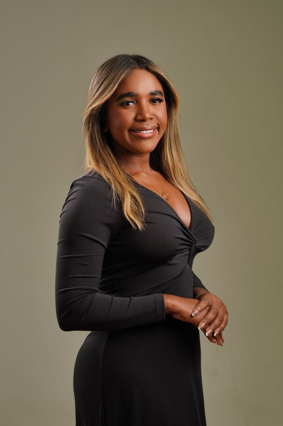 Rafaela Santos sorrindo, de vestido preto, com as mãos entrelaçadas